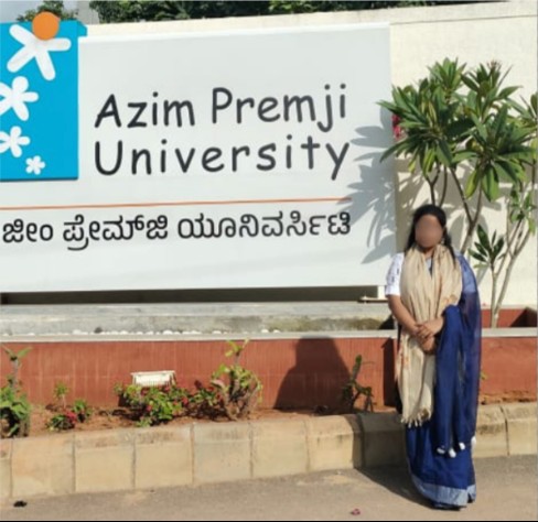Student standing outside Azim Premji University, face blurred for privacy